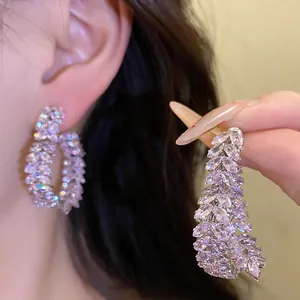 Vista detallada de pendientes de circonita con forma de espiga y agujas de plata
