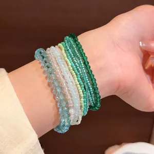 Elegante set di braccialetti di perline blu ghiaccio e verdi indossati al polso