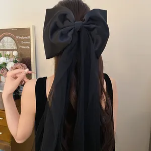 Close-up detail of the black fabric bow with elegant mesh tassel for hair styling