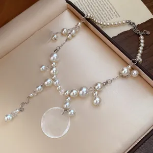 Detail shot showing the glossy pearls and shell pendant of this elegant necklace