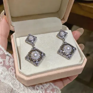 Nahaufnahme von Vintage-Rauten-Silberohrringen mit Perlen in einer rosa Geschenkbox