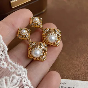 Detailansicht der geometrischen Vintage-Ohrringe in Gold mit Perlen und Kristallen