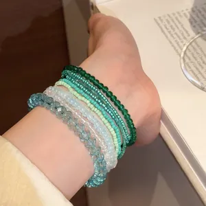 Vista dettagliata di una serie di braccialetti di perline in toni verde e blu ghiaccio