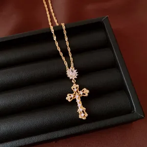 Detail van sierlijke 18k vergulde zirkoon kruis hanger in een zwarte geschenkdoos.