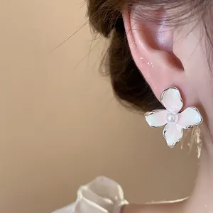 Primer plano de un elegante pendiente de flor y perla de estilo francés
