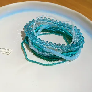 Dettaglio del set di braccialetti a strati in cristallo blu ghiaccio e perline