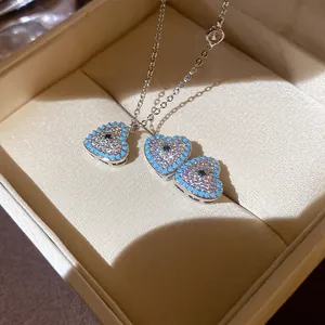 Close-up of heart-shaped pendant necklace with turquoise beads and zircon inlay