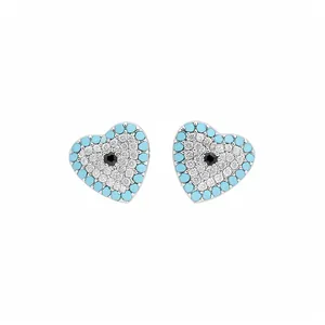 Macro detail of heart-shaped evil eye stud earrings with blue and clear zircons