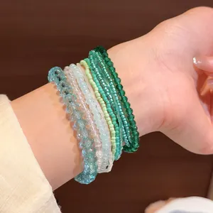 Primo piano dettagliato di un set di eleganti bracciali di perline blu e verdi sul polso