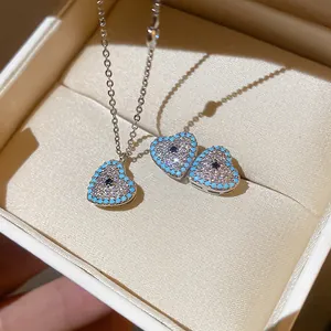 Close-up of heart-shaped zircon necklace and earrings set with turquoise accents