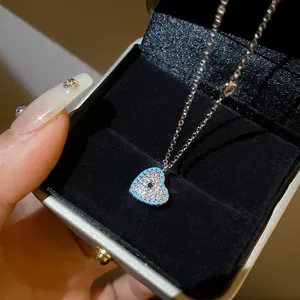 Close-up view of heart pendant necklace with blue accents in a luxury gift box.