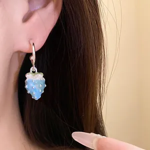 Detailed view of a sweet blue enamel strawberry pendant earring with silver needles