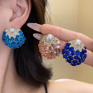 Primer plano de las tres variantes de color de estos pendientes vintage con perlas y strass.