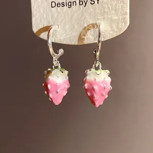Detail showing pink and white gradient enamel strawberry pendants on silver hoops