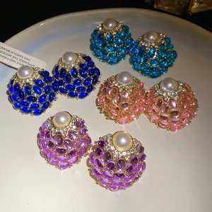 Vista detallada de pendientes vintage con perlas y piedras preciosas de cuatro colores