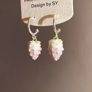 Close-up of sweet pink strawberry pendant earrings with green leaf details