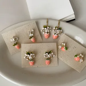 Elegant close-up of sweet flower strawberry earrings with crystals on display cards