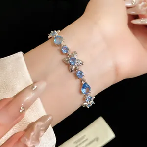 Gros plan d'un élégant bracelet en zircon avec motifs de fleurs et de gouttes d'eau au poignet