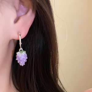 Detailed close-up showing a person wearing a lavender enamel strawberry pendant earring