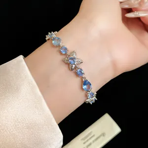 Gros plan d'un élégant bracelet en argent avec fleurs et gouttes en zircon bleu brillant