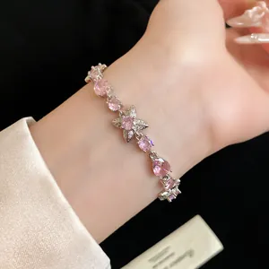 Vue détaillée d'un bracelet fleur en zircon rose au poignet d'une femme en argent