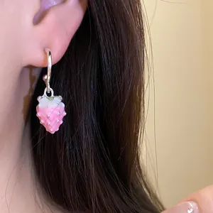 Detailed macro view of a sweet pink enamel strawberry pendant earring on a silver hoop