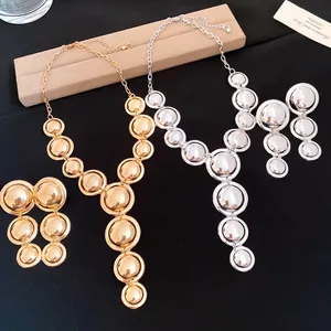 Detailed view of the smooth metallic gold and silver necklace and earring sets.