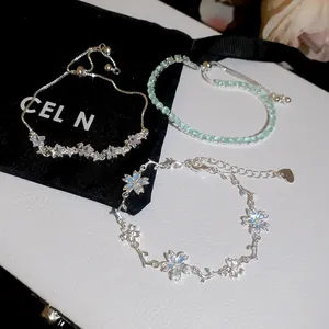 Primo piano di delicati bracciali con stelle in zircone e fiori di ciliegio.