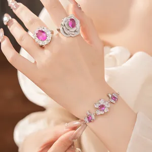 Detailaufnahme eines eleganten rosa Blumen-Schmucksets mit Armband und Ringen an der Hand