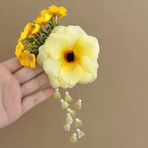 Vibrant yellow flower hair clip with dangling tassel beads for summer hairstyles.