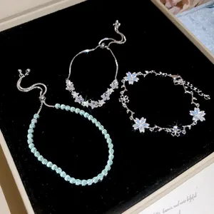 Vista dettagliata di tre squisiti braccialetti argentati presentati su velluto nero classico