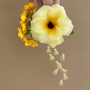 Close-up detail of a bright yellow flower hair clip with elegant floral tassels and beads