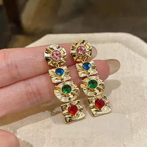 Detailed view of gold vintage-style earrings with multi-colored geometric crystals