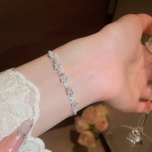 Primo piano di un elegante braccialetto a stella in zircone d'argento sul polso di una donna.