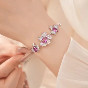 Detailansicht eines eleganten Silberarmbands mit rosa floralem Zirkonia-Inlay am Handgelenk.