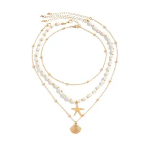 Detail view of summer layered necklace featuring gold starfish and seashell pendants