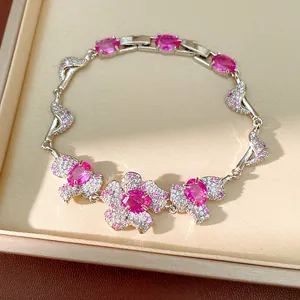 Elegante Nahaufnahme eines versilberten Armbands mit pinkfarbenen Zirkonia-Blütensteinen.