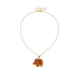 Minimalist gold chain necklace with a textured resin elephant pendant and rhinestone eye