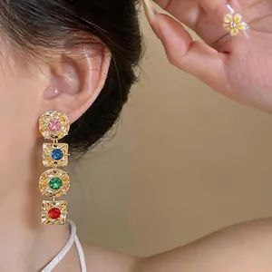 Detailed close-up of vintage geometric drop earrings with vibrant colorful gemstones