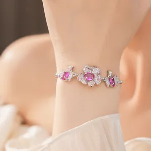 Detailansicht eines rosa Blumenarmbands mit funkelnden Zirkonia am Handgelenk eines Modells.