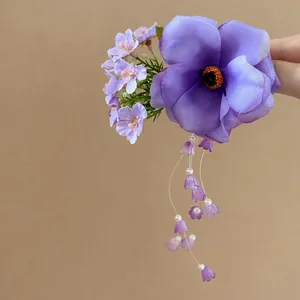 Detailed view of a purple floral hair clip with delicate tassels and bead accents