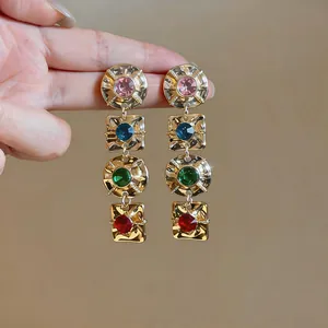 Close-up of vintage geometric drop earrings with vibrant multi-colored rhinestones