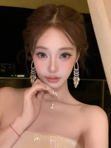 Close-up of elegant silver tassel earrings with cubic zirconia drops on an Asian model