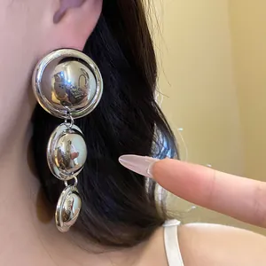 Close-up of vintage minimalist silver metal tiered circular drop earrings for women