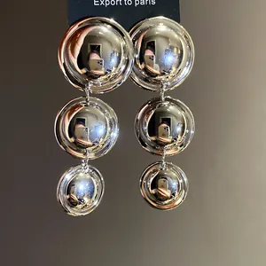 Detailed view of large vintage metallic silver triple circle drop earrings for women