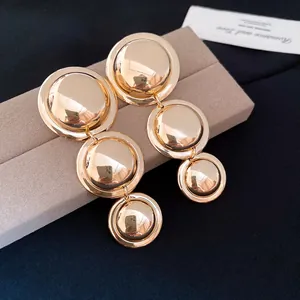 Close-up of polished gold-toned tiered circular earrings presented on a jewelry box