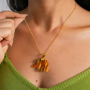 Close-up of a resin elephant pendant with tiger's eye pattern on a gold chain