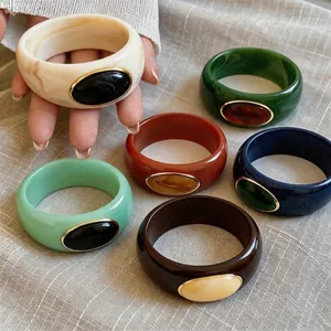 Colorful chunky acrylic marbled bangles with decorative gold-rimmed oval insets