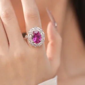 Nahaufnahme eines luxuriösen Rings mit rosa Zirkon, umgeben von weißen Steinen.