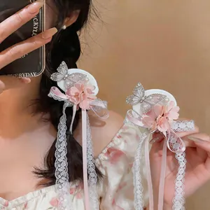Detail view of pink chiffon flower hair clip with butterfly and lace ribbon